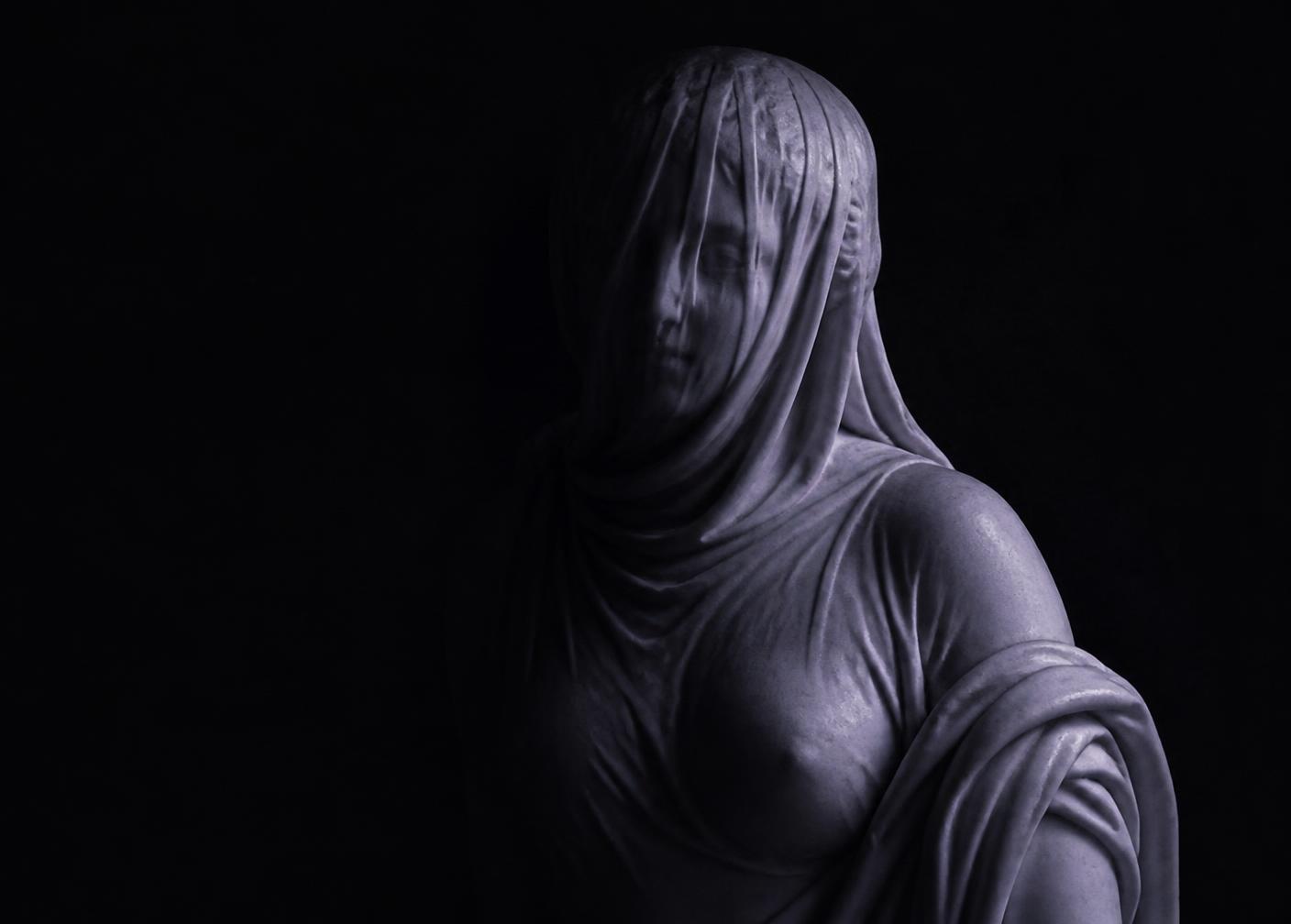 A veiled feminine figure lit in deep violet shadow, representing a deity connection session